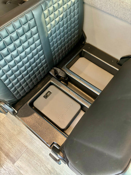 Secure storage in an RV rental: a SnapSafe portable safe nestled between quilted seats.