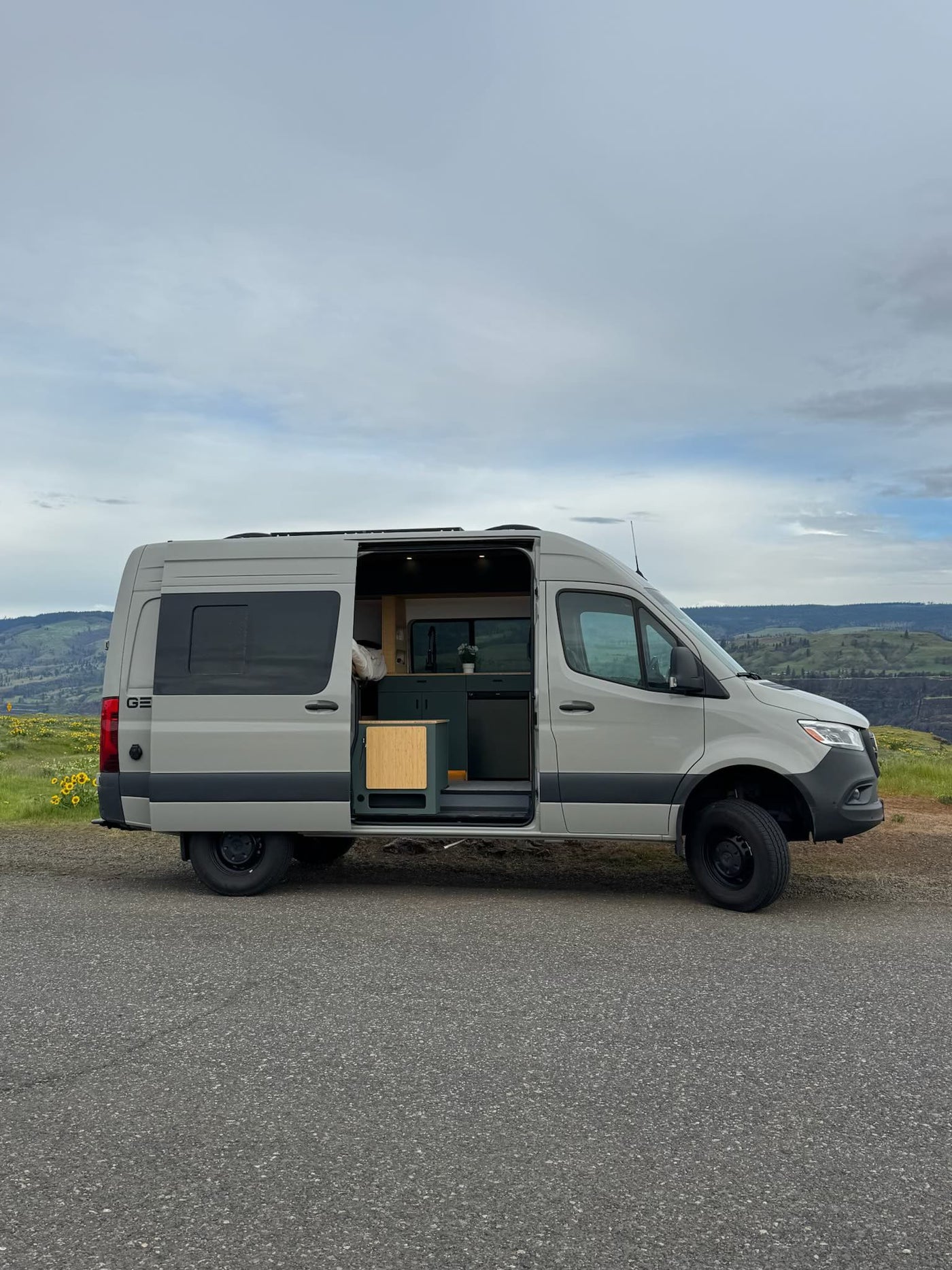 Modern gray camper van rv rental with open door revealing interior kitchen — photo 1