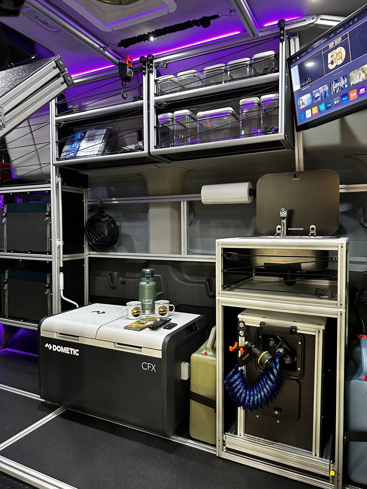 Fully equipped RV rental: Dometic fridge, modular storage, kitchen sink, and TV offer comfort for adventurers.