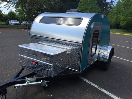 Teal & aluminum teardrop camper RV rental with front diamond plate storage boxes. Ready for road trips!