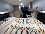 Spacious RV rental interior with comfy bed, kitchen, and ample storage, ready for your road trip.