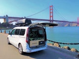 White campervan RV rental with Thule box by Golden Gate Bridge. Its open rear reveals a custom bed, ready for adventure.
