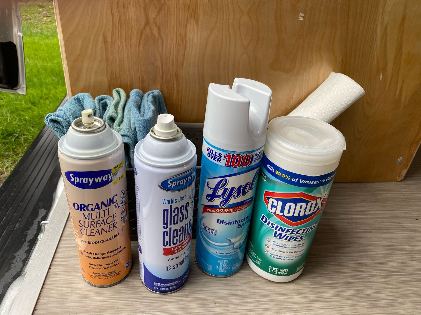 Essential cleaning supplies for an RV rental: Lysol spray, Clorox wipes, Sprayway multi-surface & glass cleaners, plus cloths.