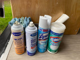 Essential cleaning supplies for an RV rental: Lysol spray, Clorox wipes, Sprayway multi-surface & glass cleaners, plus cloths.