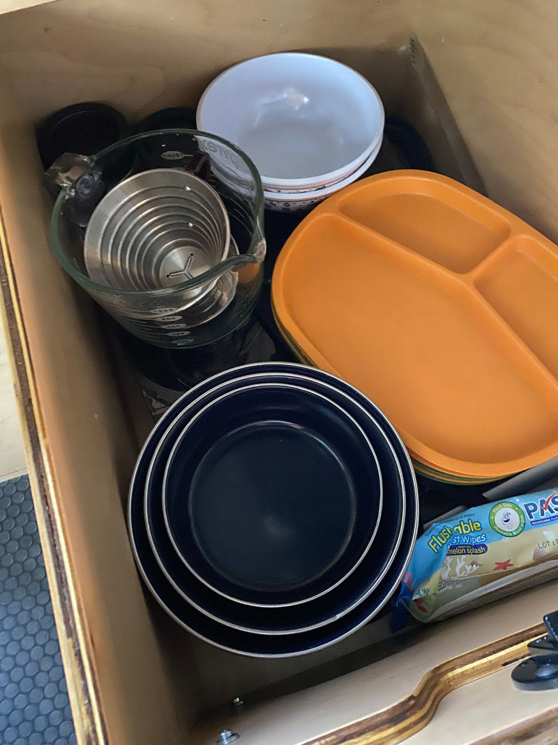 RV rental kitchen drawer: organized plates, bowls, measuring cup, and wet wipes, ready for camping trips. — photo 19