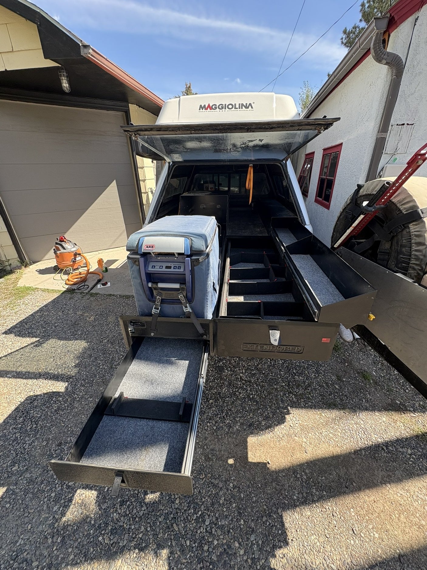 Extendobed truck bed drawer system fully extended out of a Toyota Tundra bed, with the main drawer, lower slide-out tray and the ARB fridge on its slide