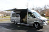 Silver Mercedes Sprinter RV rental with open door & extended awning. Luxury camper van for travel.