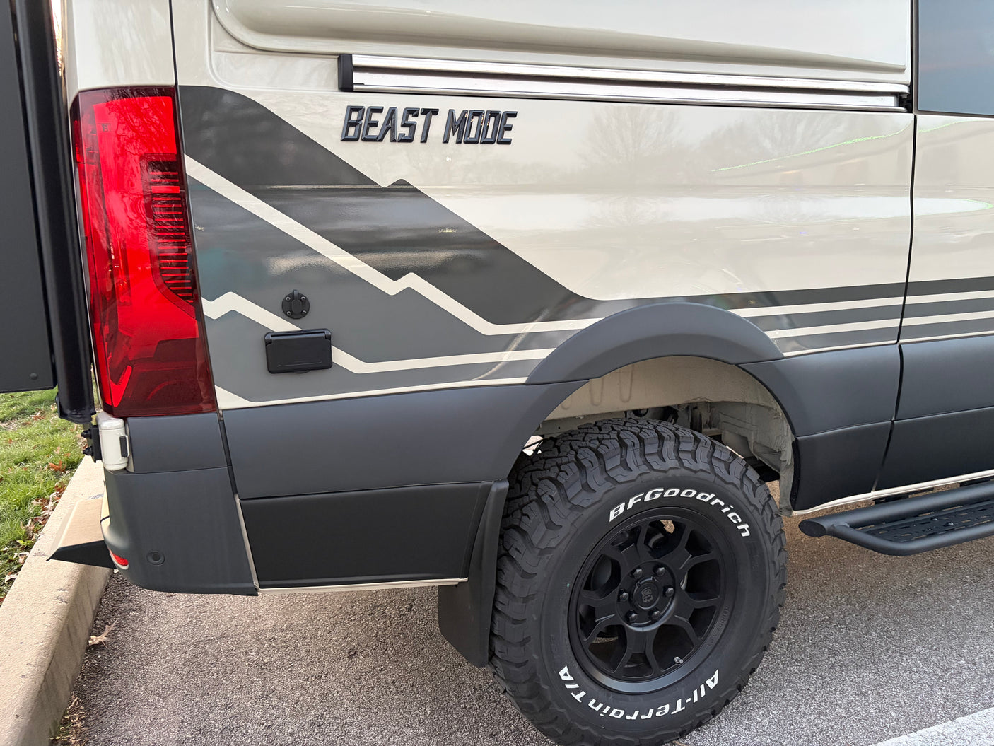 Rugged camper van rv rental featuring 'BEAST MODE' graphics, mountain design, and BFGoodrich off-road tires.