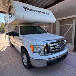  perfect for an RV rental outdoor adventure.|White Ford F-150 pickup with Adventurer truck camper