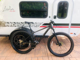 White Luna Rover **RV rental** with a black Trek mountain bike, ready for outdoor adventures.
