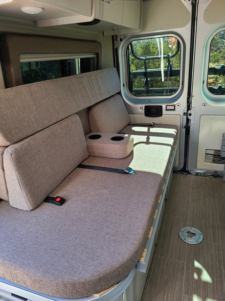RV rental: Enjoy a versatile bench seat/bed with cup holders & seatbelts inside this cozy recreational vehicle.