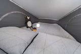 Cozy sleeping area in an RV rental, featuring a quilted bed, plush bear, and a lamp for a comfortable night.