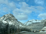 Experience a snowy mountain highway with frosted pines. An incredible winter journey awaits your RV rental.