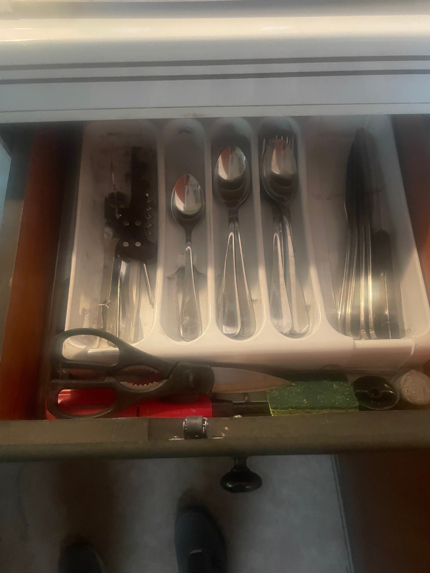 Silverware drawer with cutting knives, lighter and scissors.