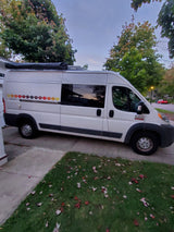 White Ram ProMaster camper van with awning & floral decals, ready for your next RV rental adventure.