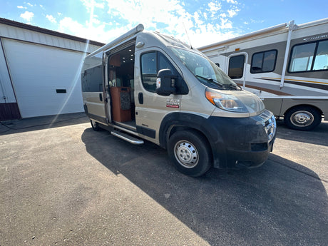Tan Ram ProMaster RV rental van with side door open, revealing interior, parked beside another RV under a sunny sky.