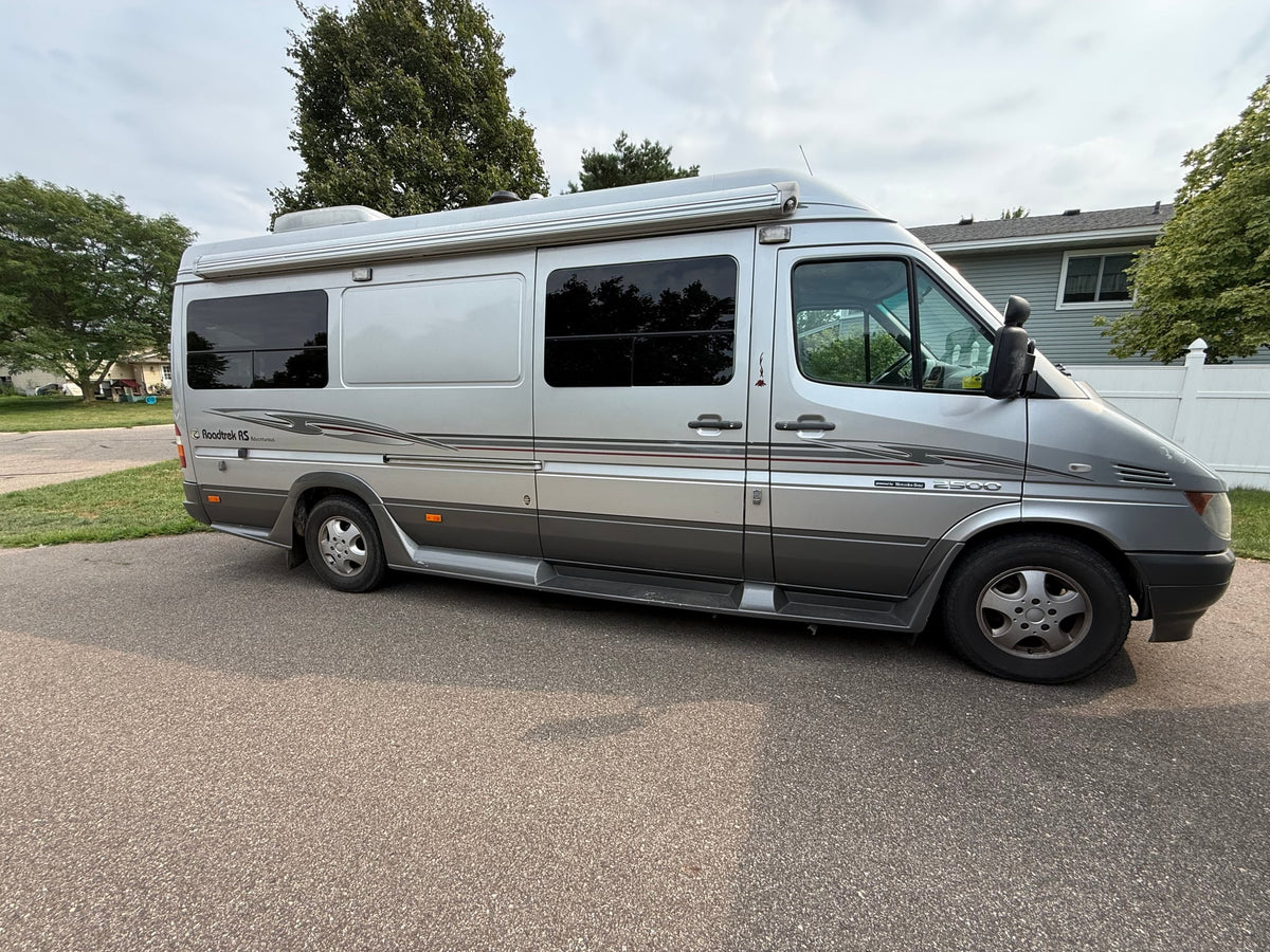 This silver Roadtrek Sprinter RV rental is a compact motorhome with an awning