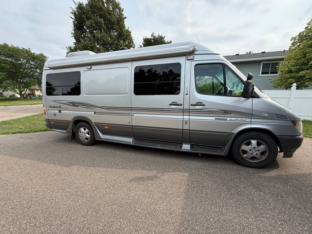 This silver Roadtrek Sprinter RV rental is a compact motorhome with an awning