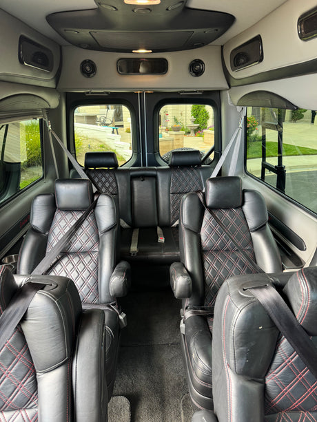 Luxurious black leather interior of an RV rental van with diamond stitching, ready for comfortable travel.