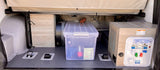 RV rental storage area featuring a water utility panel, clear bin with gear, and floor tie-downs for secure travel.