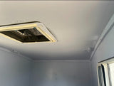 RV rental interior: a light gray ceiling with a central roof vent and a side window, providing natural light.