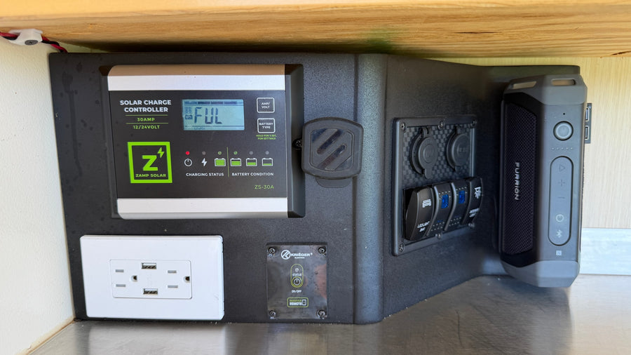 RV rental's power station: Zamp Solar controller (FUL charge, LiFePO4), outlets, inverter remote, and Furrion speaker for adventures.