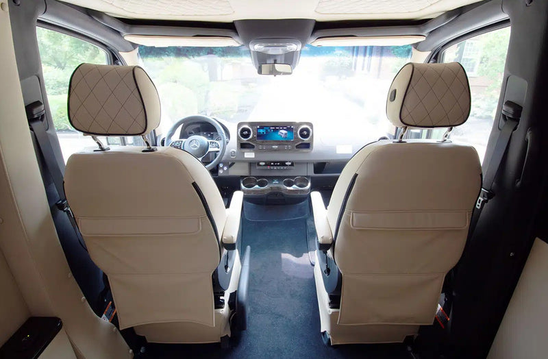  and an illuminated grab handle.|Spacious RV rental interior with luxurious cream quilted leather passenger seats — photo 9