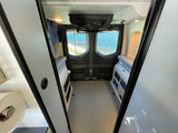 Explore with this RV rental! Inside a camper van, enjoy a water view from the rear windows, with modular interior and storage.