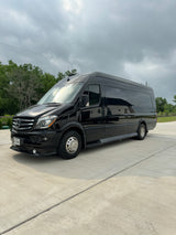 Black Mercedes-Benz Sprinter luxury RV rental van parked on concrete under an overcast sky.