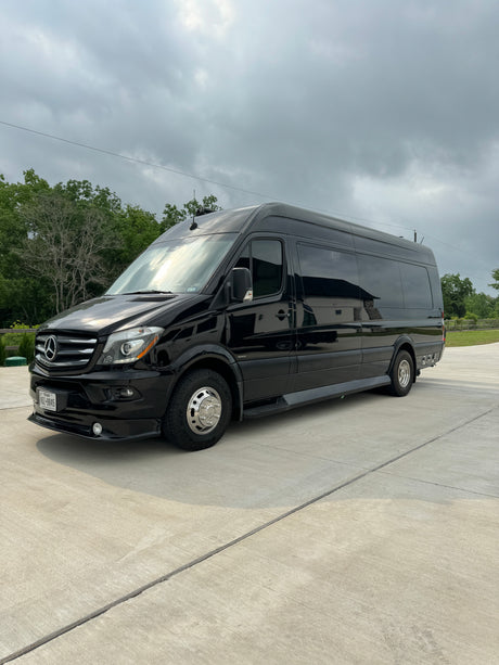 Black Mercedes-Benz Sprinter luxury RV rental van parked on concrete under an overcast sky.