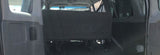 RV rental: View from rear of spacious van interior with folded bench seat and open cargo area.