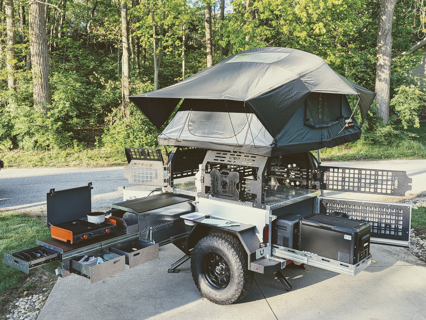 This versatile off-road camping trailer, featuring a rooftop tent & full outdoor kitchen, is ideal for your next RV rental adventure.