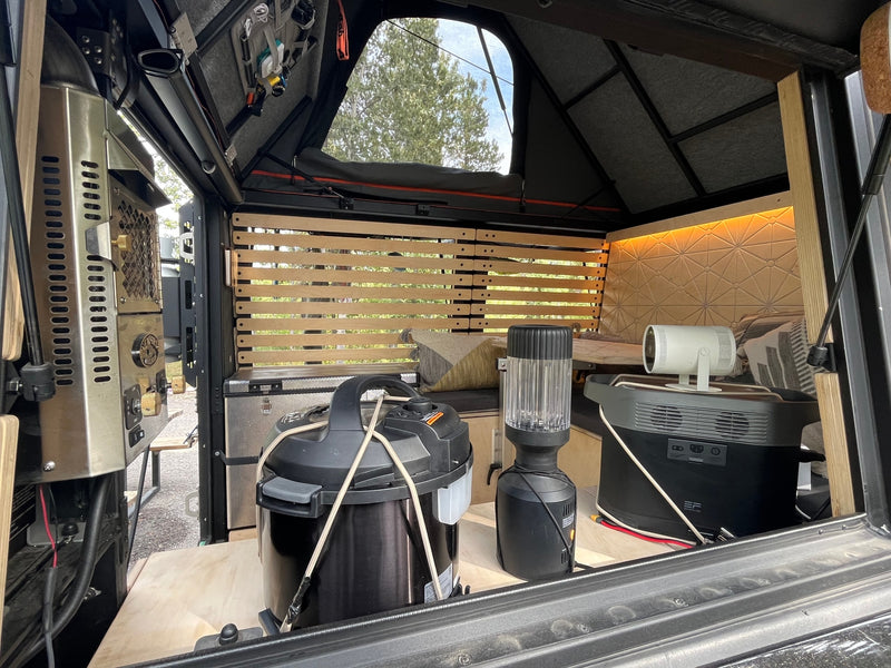 Inside an RV rental, showing a functional and organized camper setup with portable power, kitchen gear, and entertainment. — photo 16