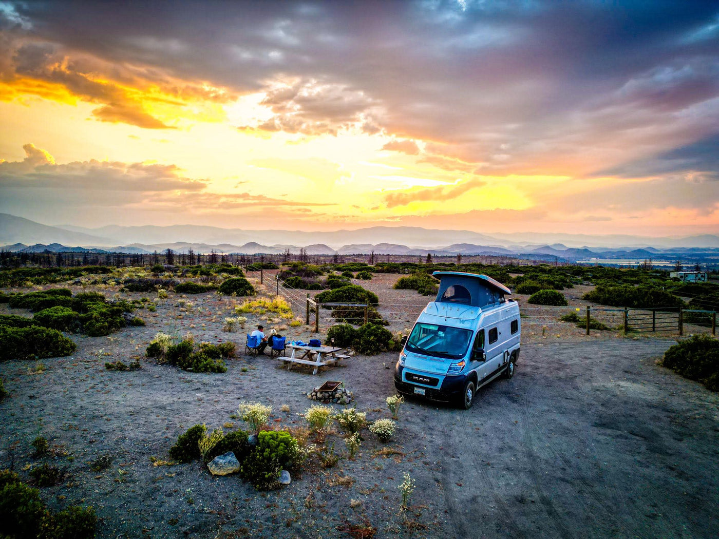  mountains under dramatic skies.|Enjoy an RV rental adventure! Silver camper van with pop-top at dusk — photo 9