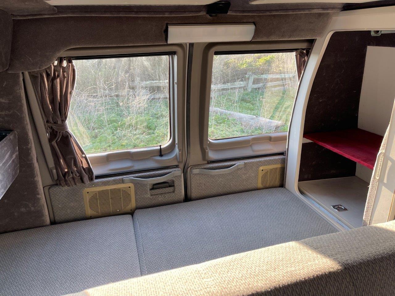  and storage.|Inside an RV rental: view of the gray upholstered seating/bed area — photo 8