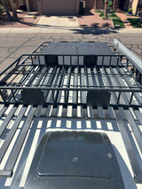 Overhead view of an RV rental roof, featuring a large black roof rack with solar panels and a vent.