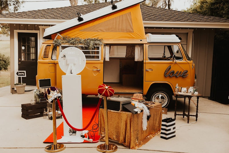 A cheerful yellow VW rv rental van set up as a photo booth with props and red carpet for events. — photo 7