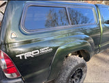 Green Toyota Tacoma TRD Off Road pickup truck with a matching camper shell, ready for an rv rental adventure.