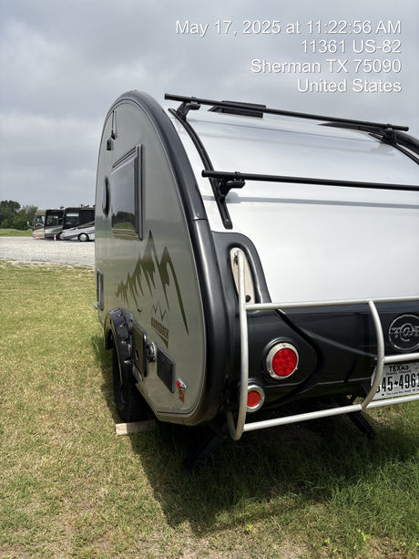 The rear of a silver Boondock travel trailer, a great option for an RV rental, parked on grass in Sherman, TX.