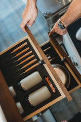 Accessing a custom-fitted drawer in an RV rental, revealing organized steak knives, Purist bottles, and a multi-tool.