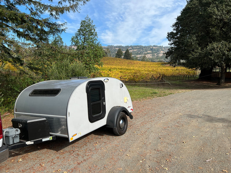  offering beautiful views of rolling hills under a blue sky.|Cozy rv rental teardrop camper setup: open outdoor kitchen & water station in a wooded campsite — photo 3