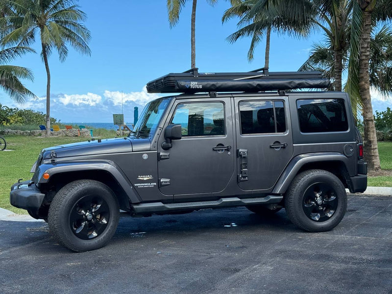 This gray Jeep Wrangler with a rooftop tent, perfect for an RV rental, is ready for tropical off-road travel and beach camping. — photo 10