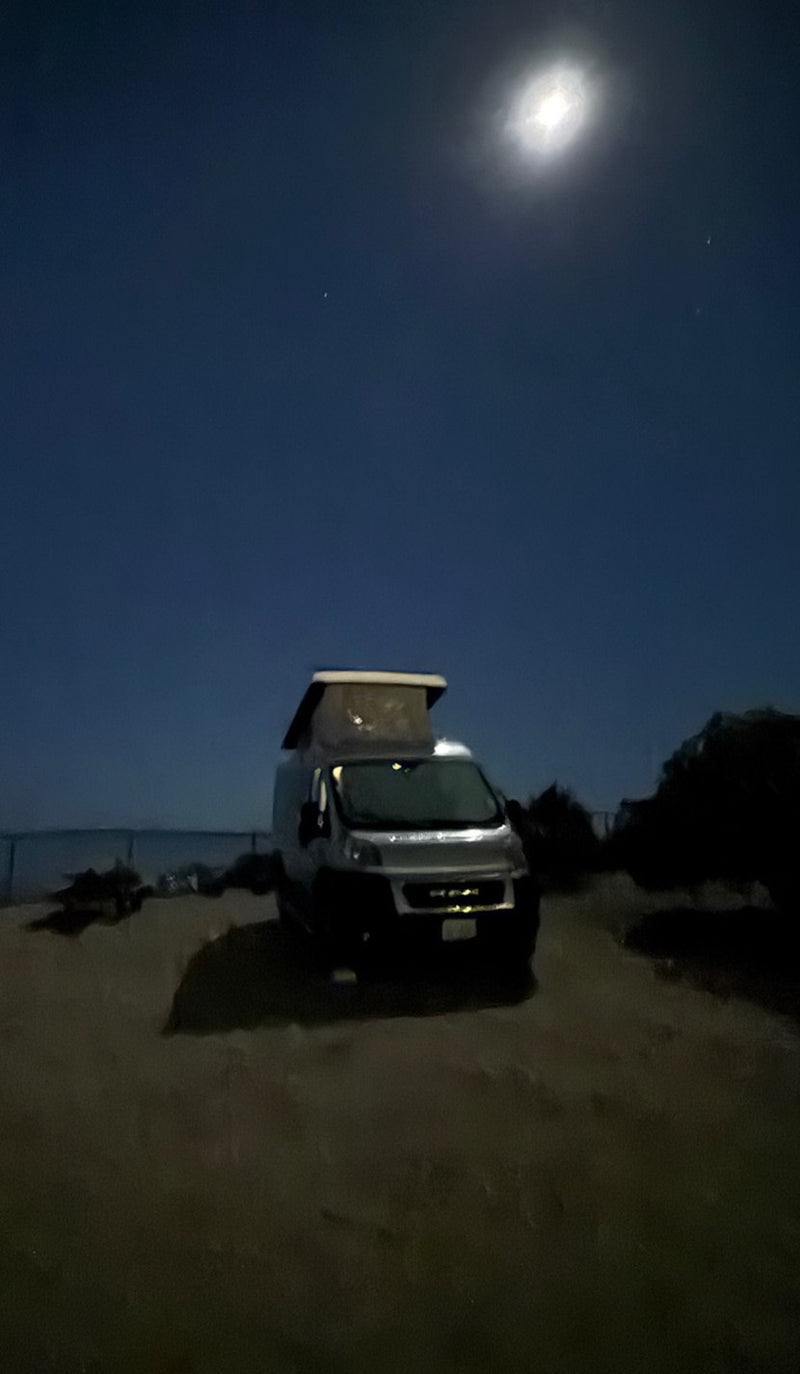  and ocean view with a fence. Enjoy coastal trips in this camper.|Explore a modern RV rental: well-appointed camper van interior with compact kitchen — photo 9