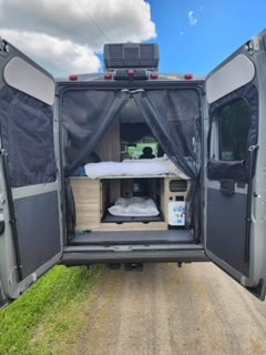 quilted RV rental passenger seating inside a modern van conversion — photo 11