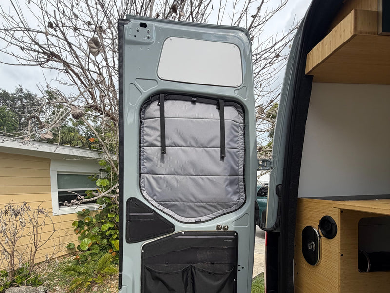  and red charging cable visible.|Detail of an rv rental van's rear door window with privacy blinds — photo 14
