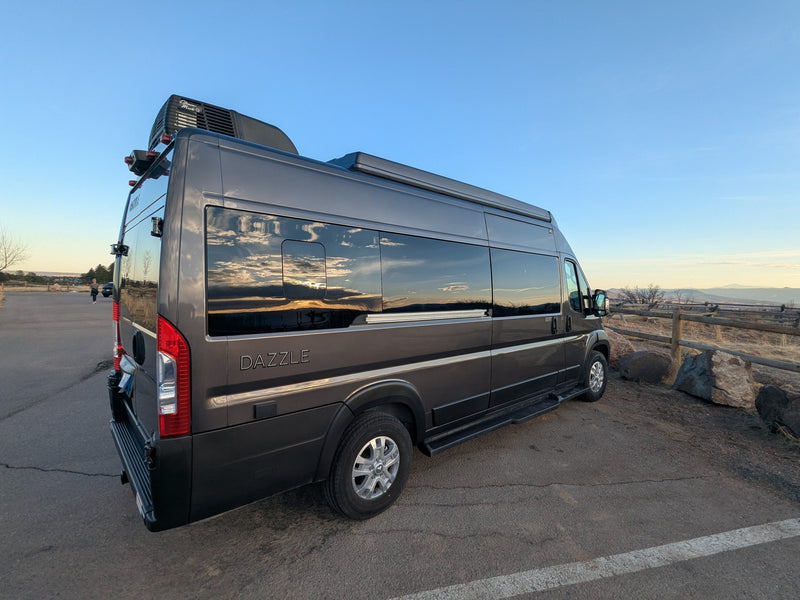Dark gray camper van, ideal for RV rental adventures, parked at a scenic outdoor overlook reflecting the sky. — photo 18