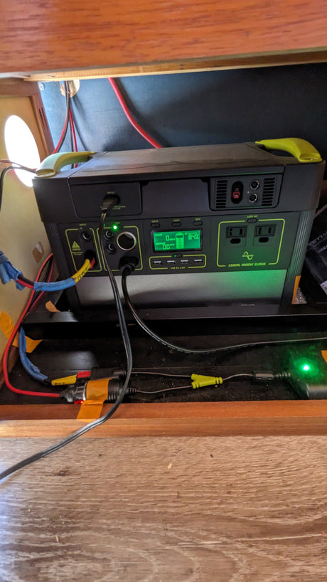 A Goal Zero portable power station (84% charged) powers devices inside an RV rental. An essential off-grid electrical setup.