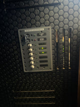 RV rental's 120V AC electrical distribution panel, with main and branch circuit breakers, status lights. Power on.