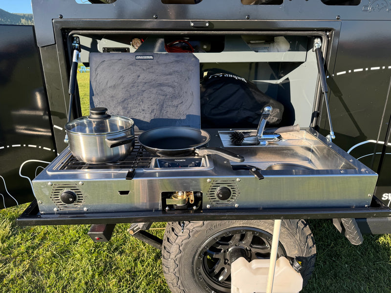 RV rental outdoor kitchen: a pull-out unit with stove, sink, pot, and pan, perfect for camping cooking. — photo 10