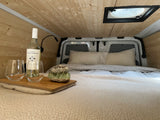 Enjoy a relaxing evening in this cozy RV rental. Features a comfy bed, wood walls, wine, and crystal decor.